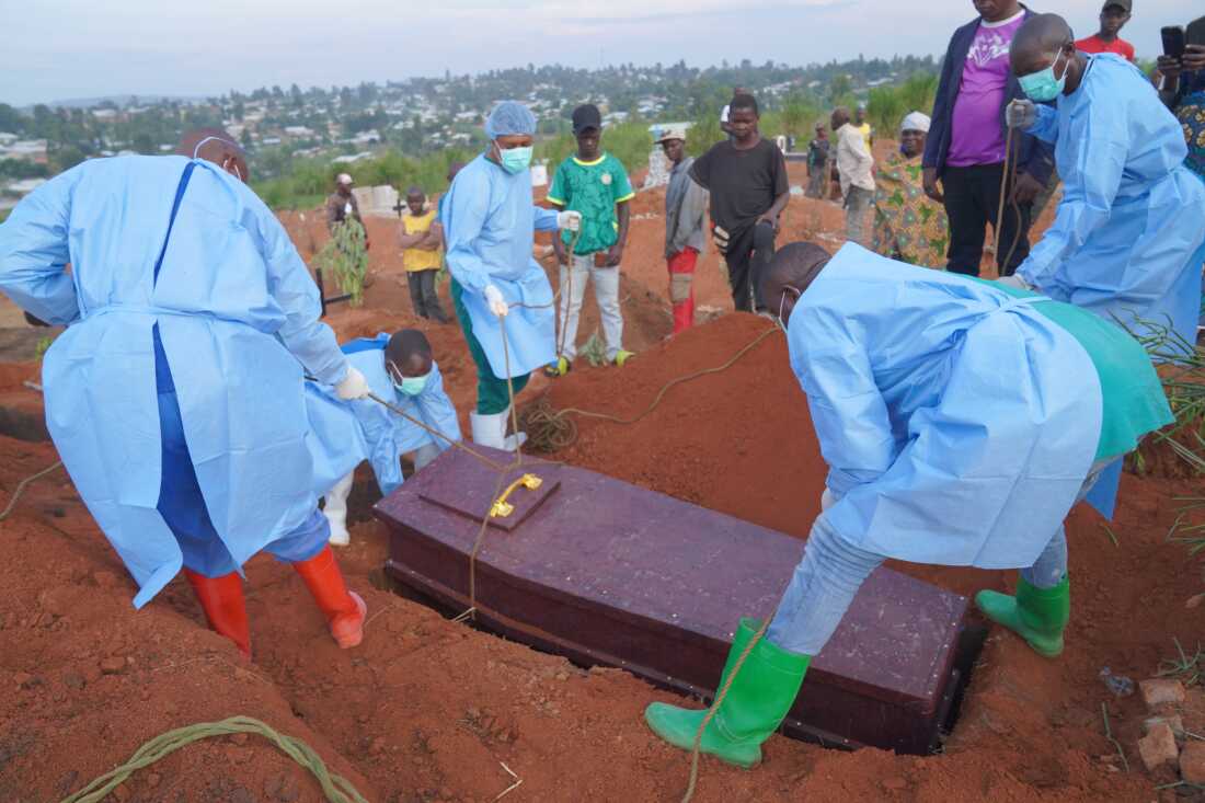 People dressed in protective gear lower into a grave the coffin containing the remains of 6-year-old Baudjo Baraka Jules, who died of Ebola, in Bunia, Ituri province, eastern Congo, Tuesday, Aug. 18, 2026.