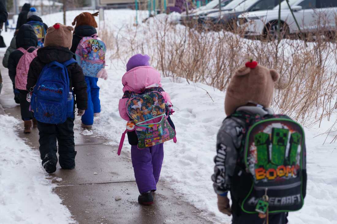 Students walk from a bus at a St. Paul School District elementary school in St. Paul, Minnesota, U.S., March 18, 2026.