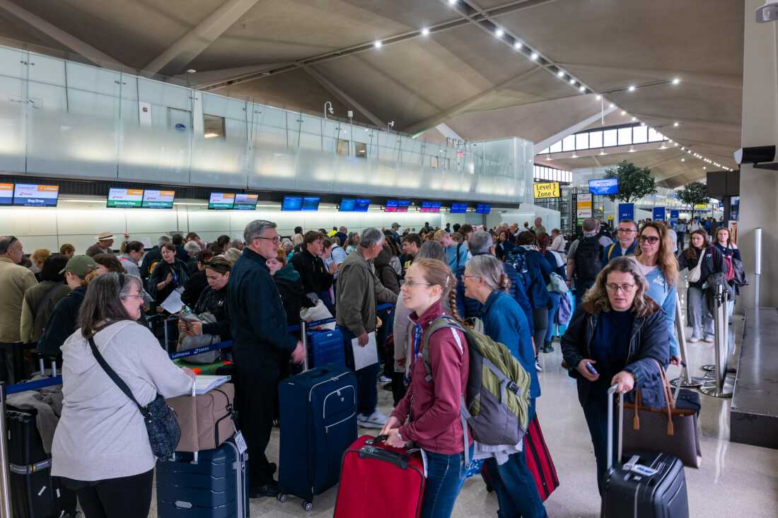 People wait in line for a delayed flight at Newark International Airport on Monday in Newark, N.J.