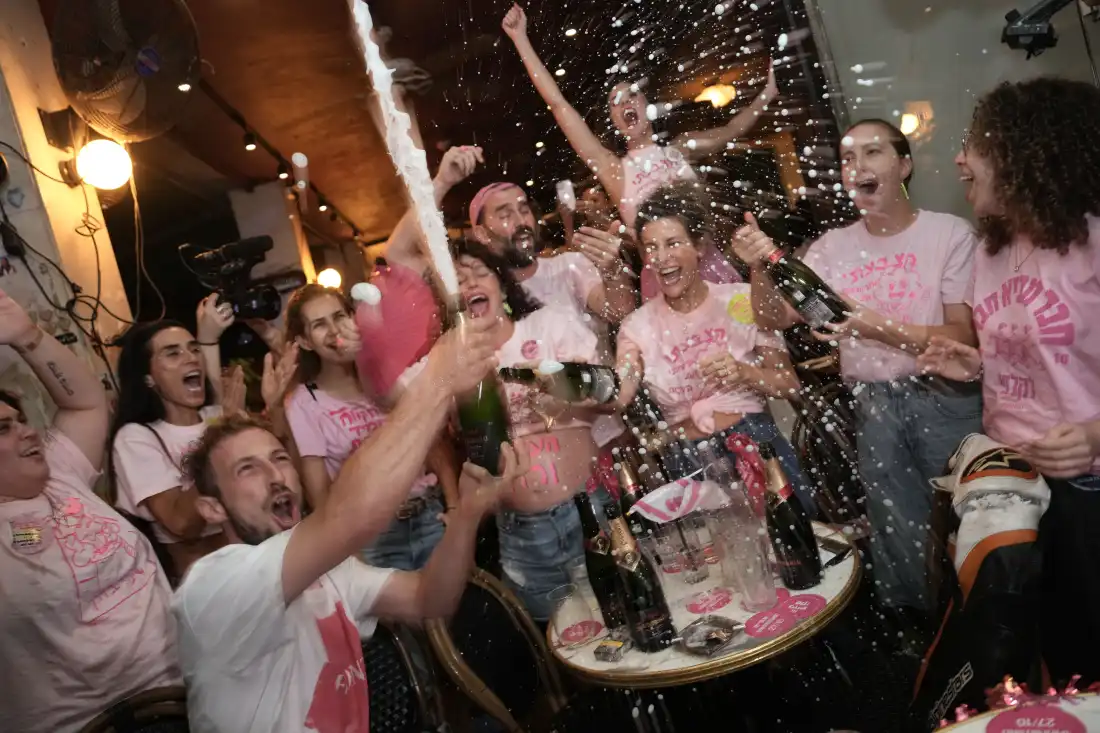 People spray sparkling wine as they celebrate early exit poll results for Israel's general election in Tel Aviv, Israel, Tuesday, Oct. 27, 2026.