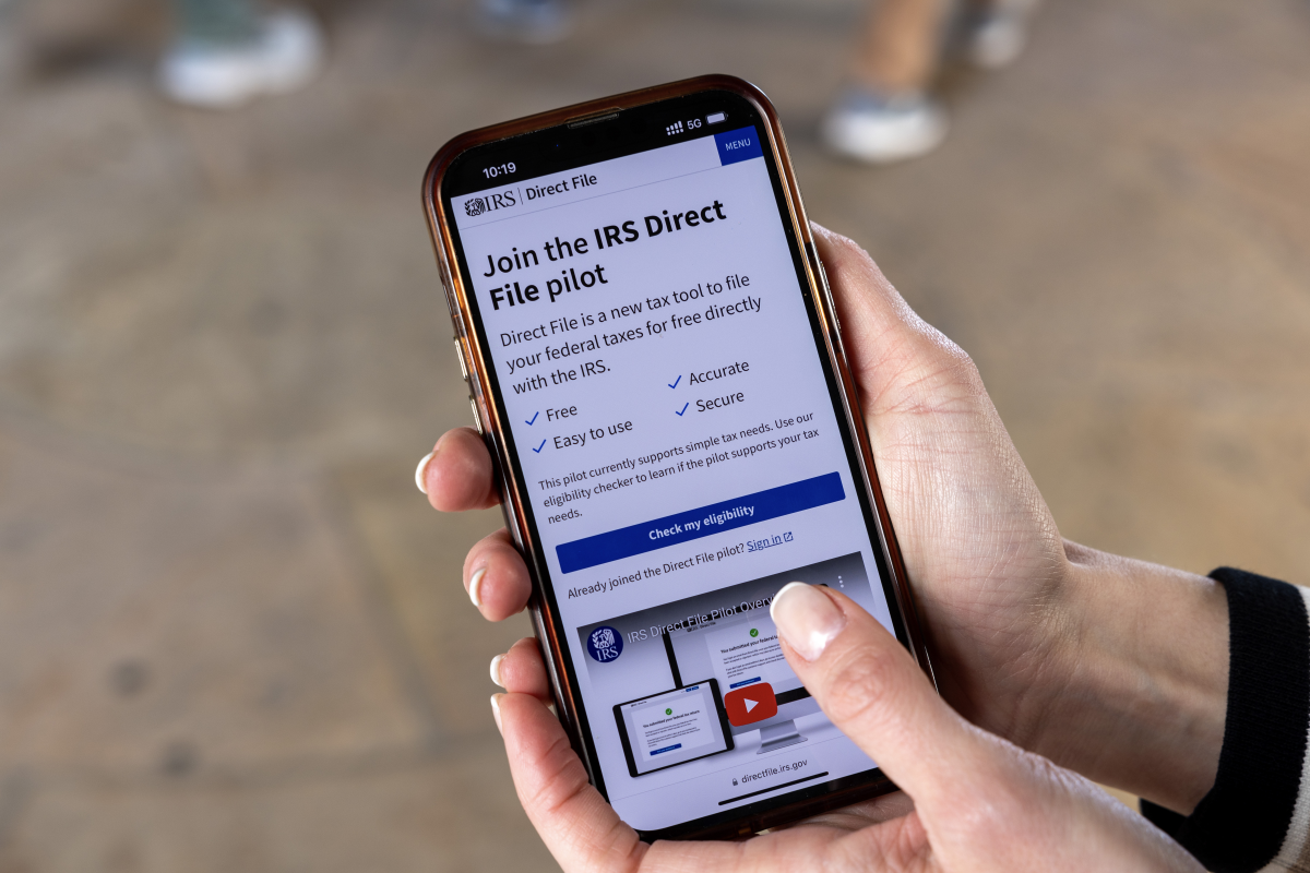 A phone user looks at information about the IRS Direct File program at the IRS building in Washington, D.C., last April. The free tax return service has now grown to 25 states.