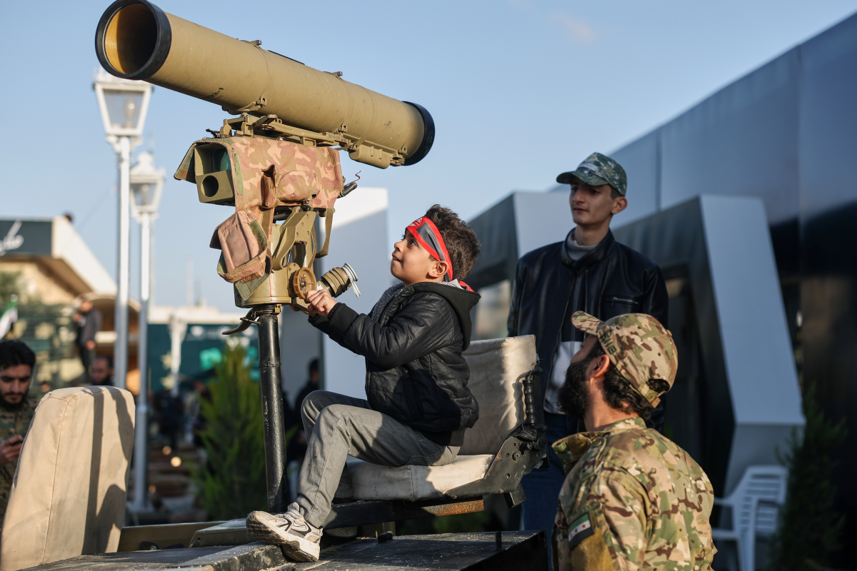 A boy checks out military equipment as visitors tour the 'Syrian Revolution Military Exhibition,' which opened last week ahead of the first anniversary of the ousting of the Bashar Assad regime in Damascus, Syria, Sunday.