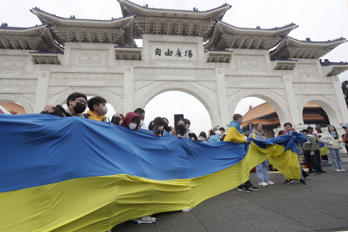 A group of Ukrainian people in Taiwan and supporters hold a Ukraine national flag  during a protest, marking one year since the Russian invasion of Ukraine, at Liberty Square in Taipei, Taiwan, Saturday, Feb. 25, 2023.