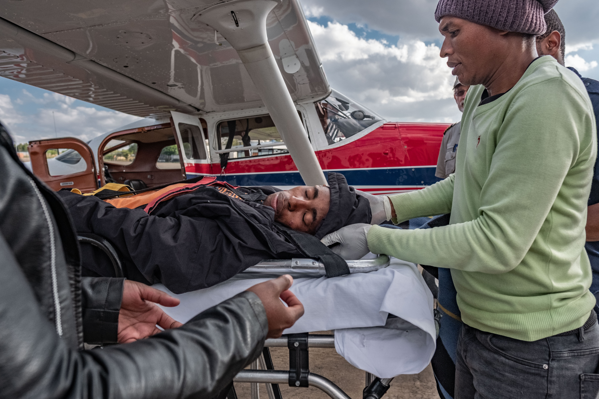 Tlotliso Lebeta, 24, sustained head injuries in a horse-riding accident. The Lesotho Flying Doctor Service flew him from his remote district of Mokhotlong to the capital city of Maseru for care. Above: Members of the LFDS team transfer him to an ambulance.