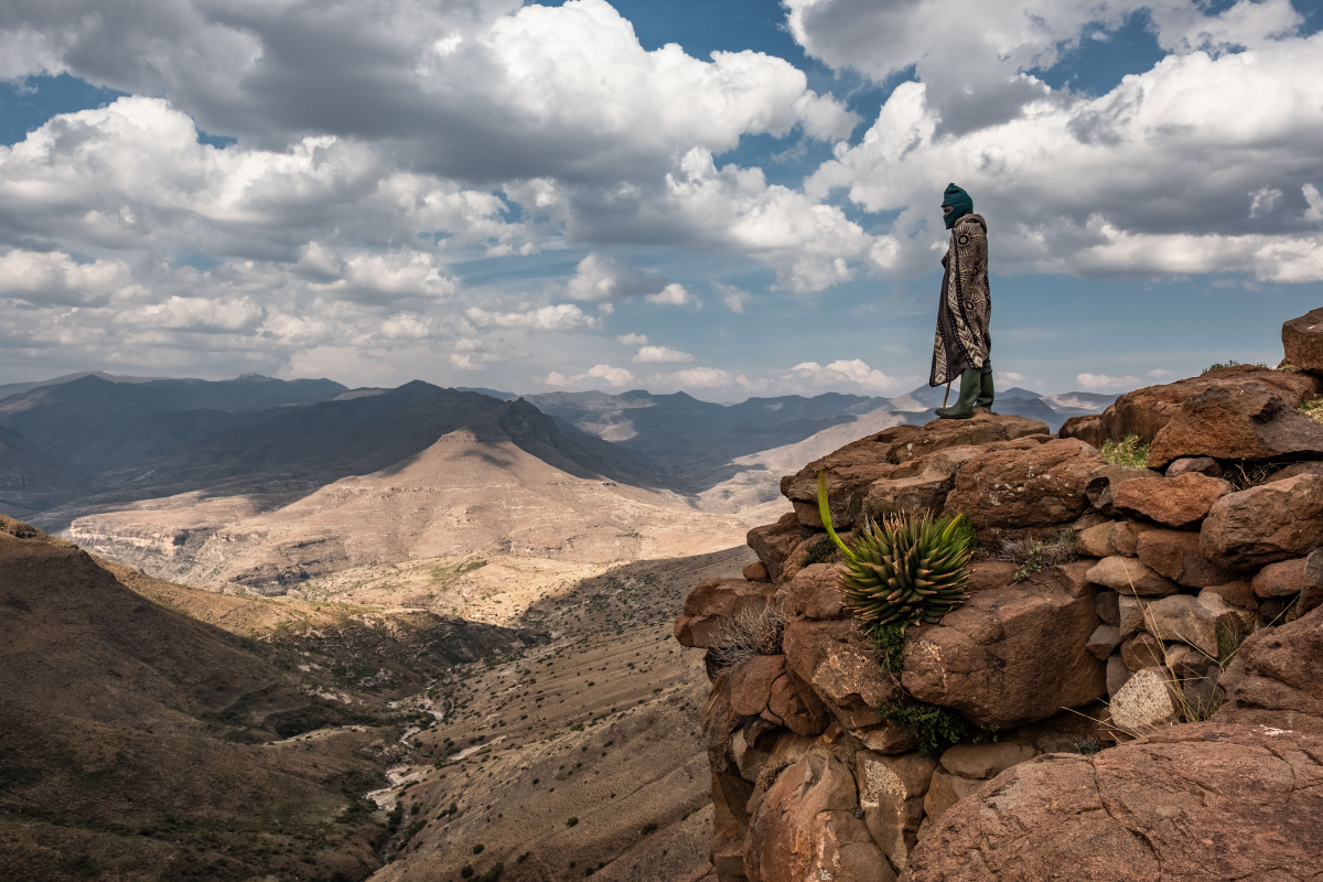 Bernard Nphukeng, a shepherd, looks out from a cliff on the edge of the isolated village of Ha Pheulane, Lesotho. He'd just had a tooth removed during a visit by staff from the Lesotho Flying Doctor Service.