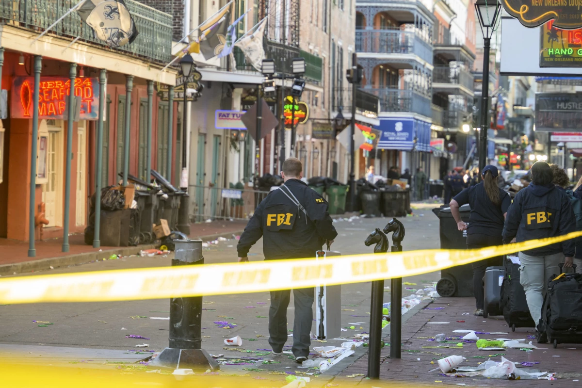FBI investigators arrive at the scene where the white Ford F-150 pickup truck that crashed into a work lift after allegedly driving into a crowd of New Year's revelers in the French Quarter of New Orleans.