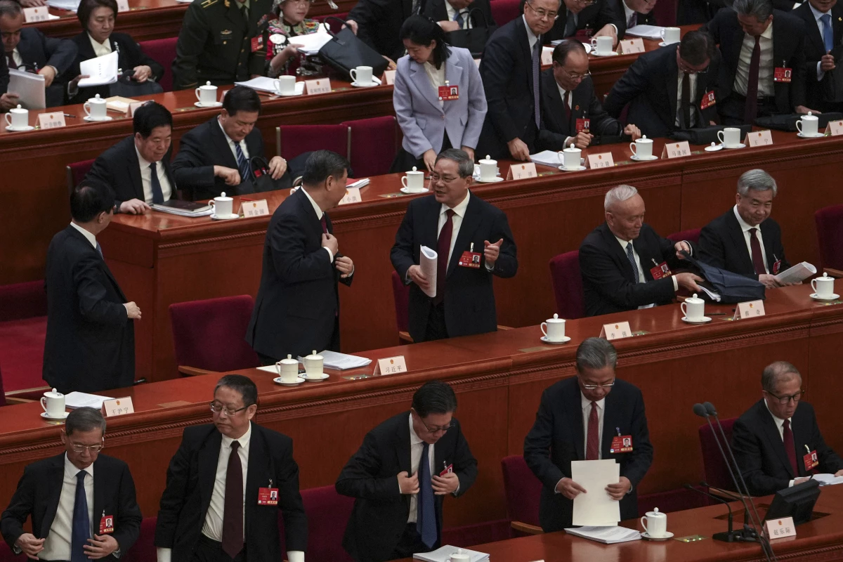 Chinese President Xi Jinping, center left, chats with his Premier Li Qiang as leaders and delegates prepare to leave after attending the opening session of the National People's Congress held at the Great Hall of the People in Beijing on Wednesday.