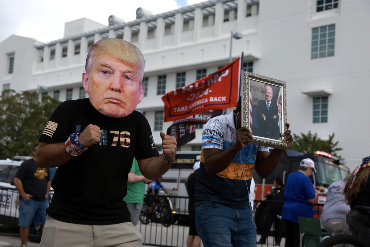 A man wears a mask of former President Donald Trump in front of a Fort Pierce, Fla., courthouse.