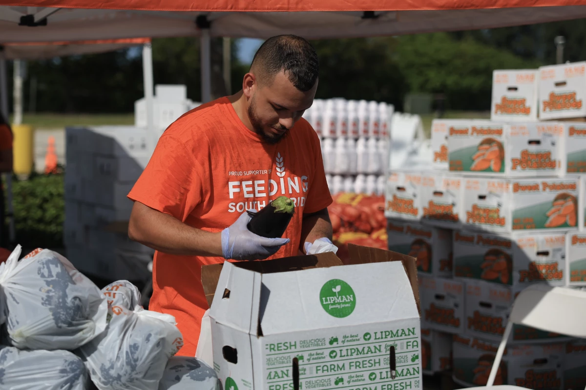 Anthony Bryant, a volunteer with Feeding South Florida, prepares food items to give to government workers on October 28, 2025 in Dania Beach, Florida. As the government shutdown nears four weeks, Feeding America and its members have been launching food distribution sites for people affected by the government shutdown.