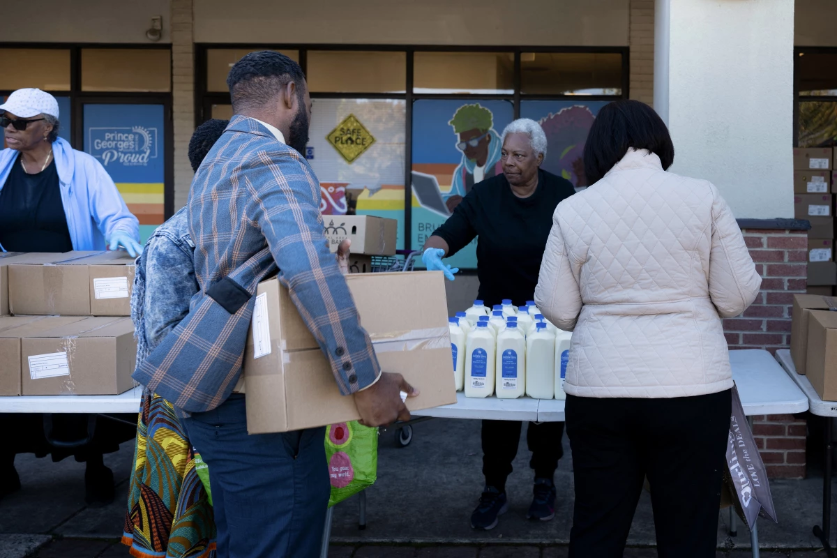 People receive food for furloughed federal workers at No Limits Outreach Ministries on Oct. 21, 2025 in Hyattsville, Md. The U.S. government shutdown dragged into a third week, with Congress gridlocked in a clash over spending and no resolution in sight to a crisis that has already cost thousands of jobs.