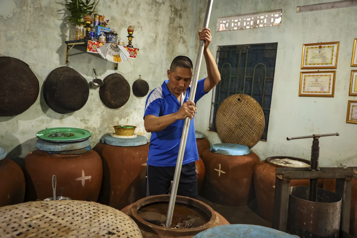 Phan Cong Quang makes fish sauce in his home in Nam O fishing village on March 4.