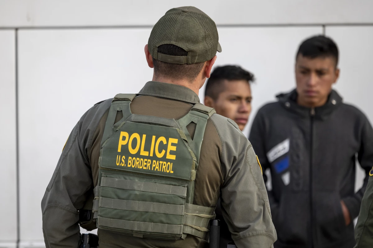 A U.S. Border Patrol agent watches as immigrants prepare to board a bus after crossing the U.S.-Mexico border on Jan. 7, 2024 in Eagle Pass, Texas.