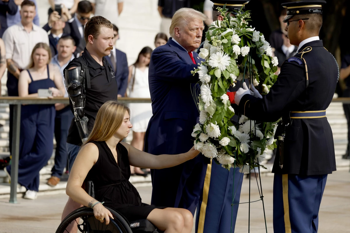 Former President Donald Trump lays a wreath alongside Marine Cpl. Kelsee Lainhart (Ret.) and U.S. Marine Corps. Sergeant Tyler Vargas-Andrews (Ret.) who were injured at the Abbey Gate Bombing, during a wreath-laying ceremony at the Tomb of the Unknown Soldier at Arlington National Cemetery on Aug. 26 in Arlington, Va.