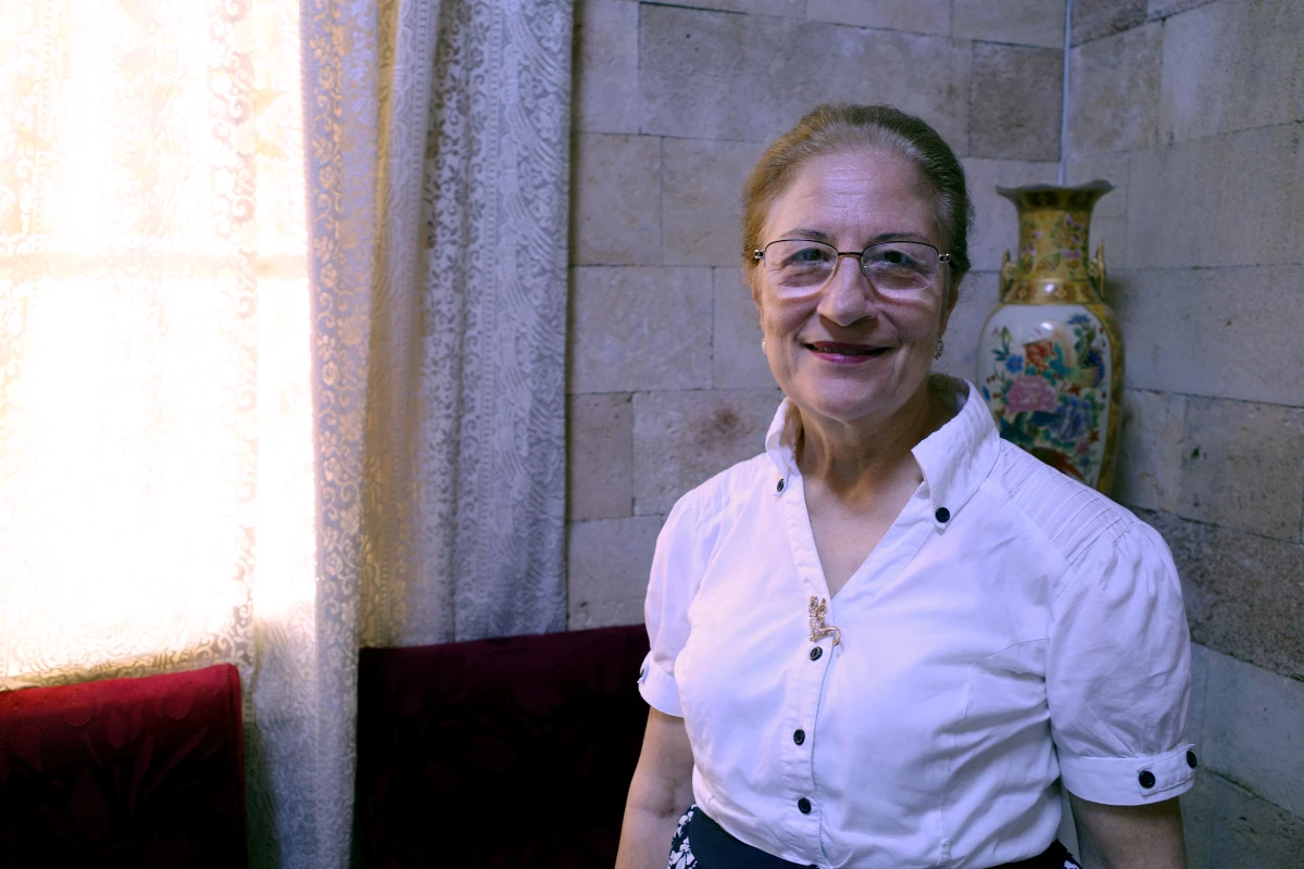 Denise Khoury, standing inside the Church of the Sacred Heart of Jesus in Latakia, says she checked on her mother's home in northern Syria after the war and found it occupied by foreign fighters.