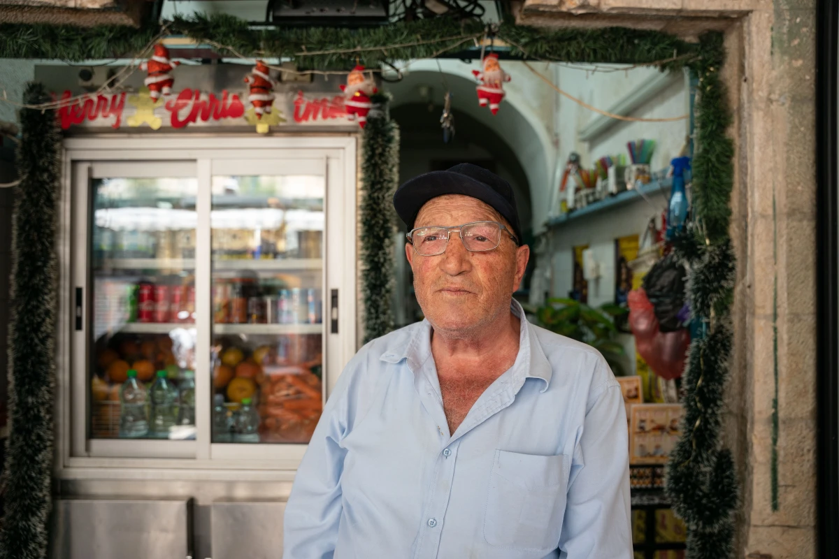 Rimon Himo, 69, a Palestinian resident of the Old City of Jerusalem, stands in front of his shop after being attacked by a mob.