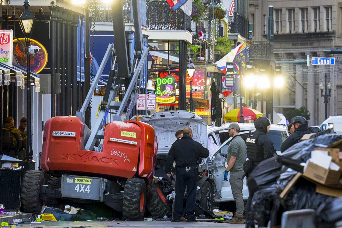 TPolice investigators surround the white Ford F-150 pickup truck that crashed into a work lift after allegedly driving into a crowd of New Year's revelers in the French Quarter of New Orleans.