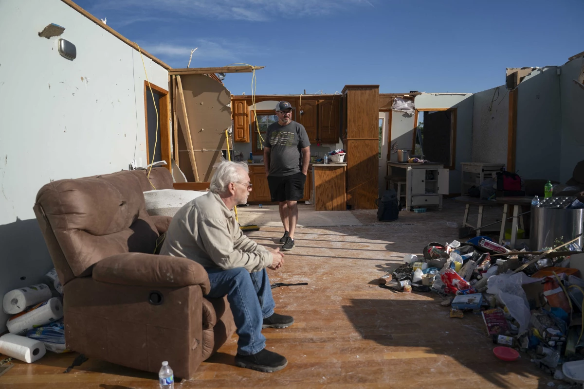 People in the remnants of a home in London, Kentucky after it was hit by a tornado in May 2025. Home insurance costs are expected to increase this year in states that have suffered hail and tornado damage from big convective storms.