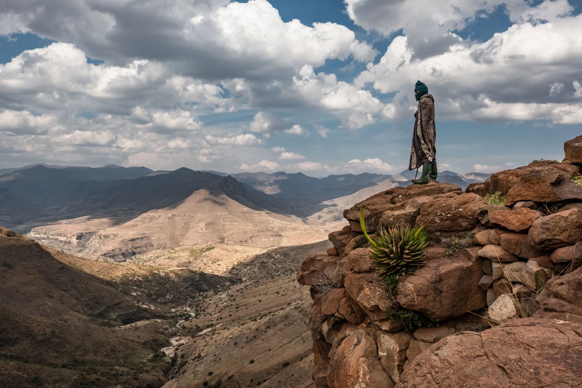 Bernard Nphukeng, a shepherd, looks out from a cliff on the edge of the isolated village of Ha Pheulane, Lesotho. He'd just had a tooth removed during a visit by staff from the Lesotho Flying Doctor Service.