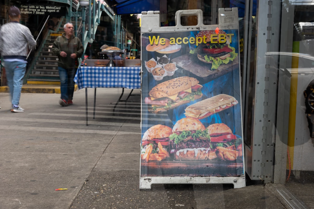A sign outside of a grocery store welcomes those on food assistance in a Brooklyn neighborhood that has a large immigrant and elderly population on Oct. 16, 2023 in New York City.