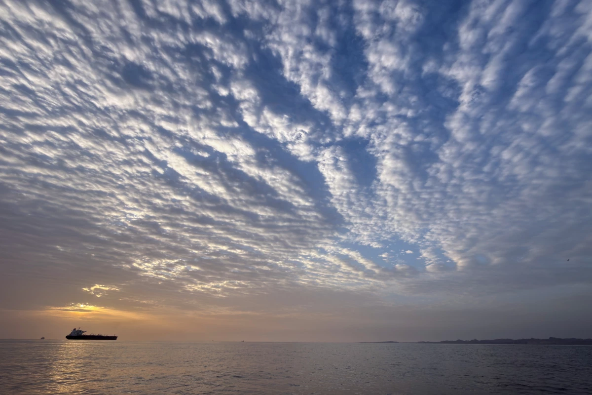The sun rises behind a tanker anchored in the Strait of Hormuz off the coast of Qeshm Island, Iran, Saturday, April 18, 2026.