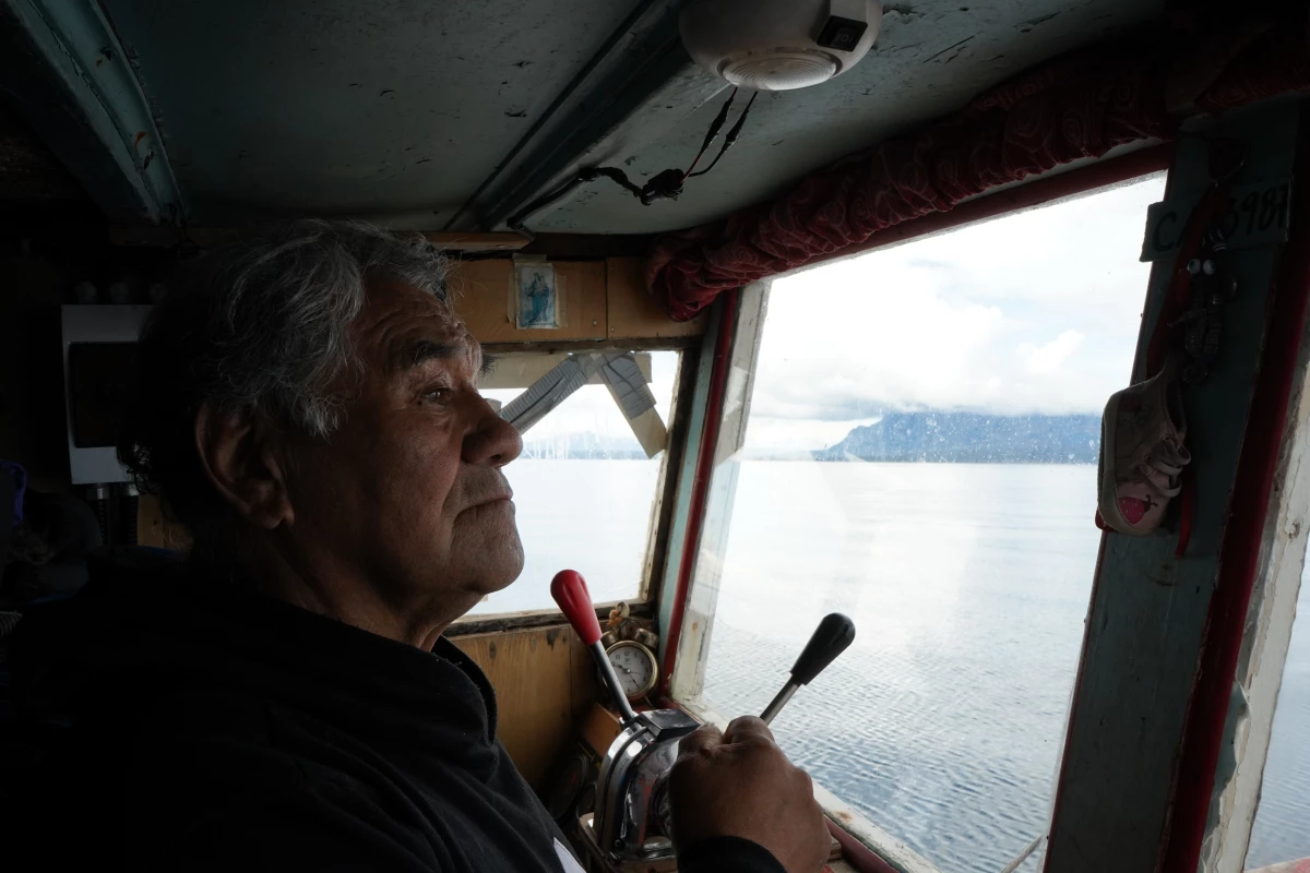 Reinaldo Caro surveys the shoreline of the Almirante Montt Gulf from the cabin of the Calipso on his way through the fjords toward the Kirke Channel.