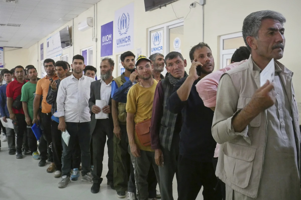 Afghan refugees who returned after fleeing Iran to escape deportation and conflict line up at a UNHCR facility near the Islam Qala crossing in western Herat province, Afghanistan, on Friday, June 20, 2025.