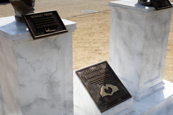 The plaque beneath the statue is titled "In Honor of Friendship Month."