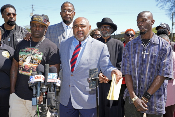 Michael Corey Jenkins, right, and Eddie Terrell Parker, left, stand with their local attorney Trent Walker, as he calls on a federal judge at a news conference on March 18 in Jackson, Miss.,