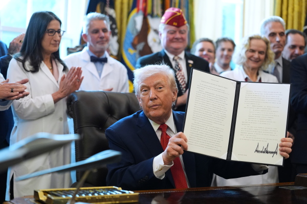 President Trump displays an executive order reclassifying marijuana as a less dangerous drug in the Oval Office on Dec. 18.