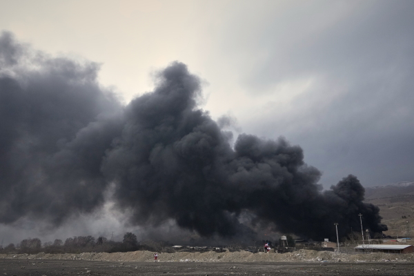 A thick plume of smoke rises from an oil storage facility hit by a U.S.-Israeli strike late Saturday in Tehran, Iran, Sunday, March 8, 2026.
