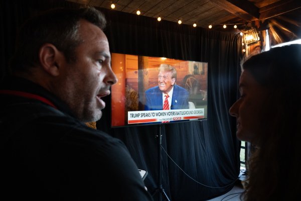 News photographers watch Republican presidential nominee, former President Donald Trump on-screen at a town hall event hosted by Fox News on Tuesday in Cumming, Ga.