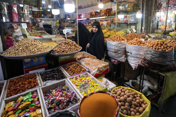 Women shop from a dried fruits, nuts, and spice trader's at the old Shapur Bazaar in southern Tehran on Aug. 5, 2025. (Photo by ATTA KENARE / AFP) (Photo by ATTA KENARE/AFP via Getty Images)