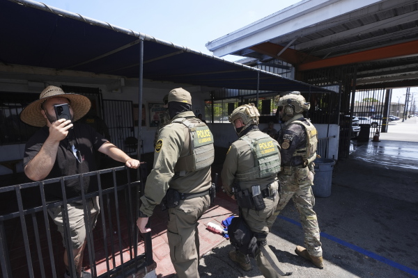 Immigration agents conduct an operation at a car wash on Friday, Aug. 15, 2025, in Montebello, Calif.