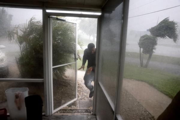 Chris Williams runs through a rain storm as he packs his car to evacuate his apartment in Fort Myers, Fla., on Wednesday before Hurricane Milton's arrival.