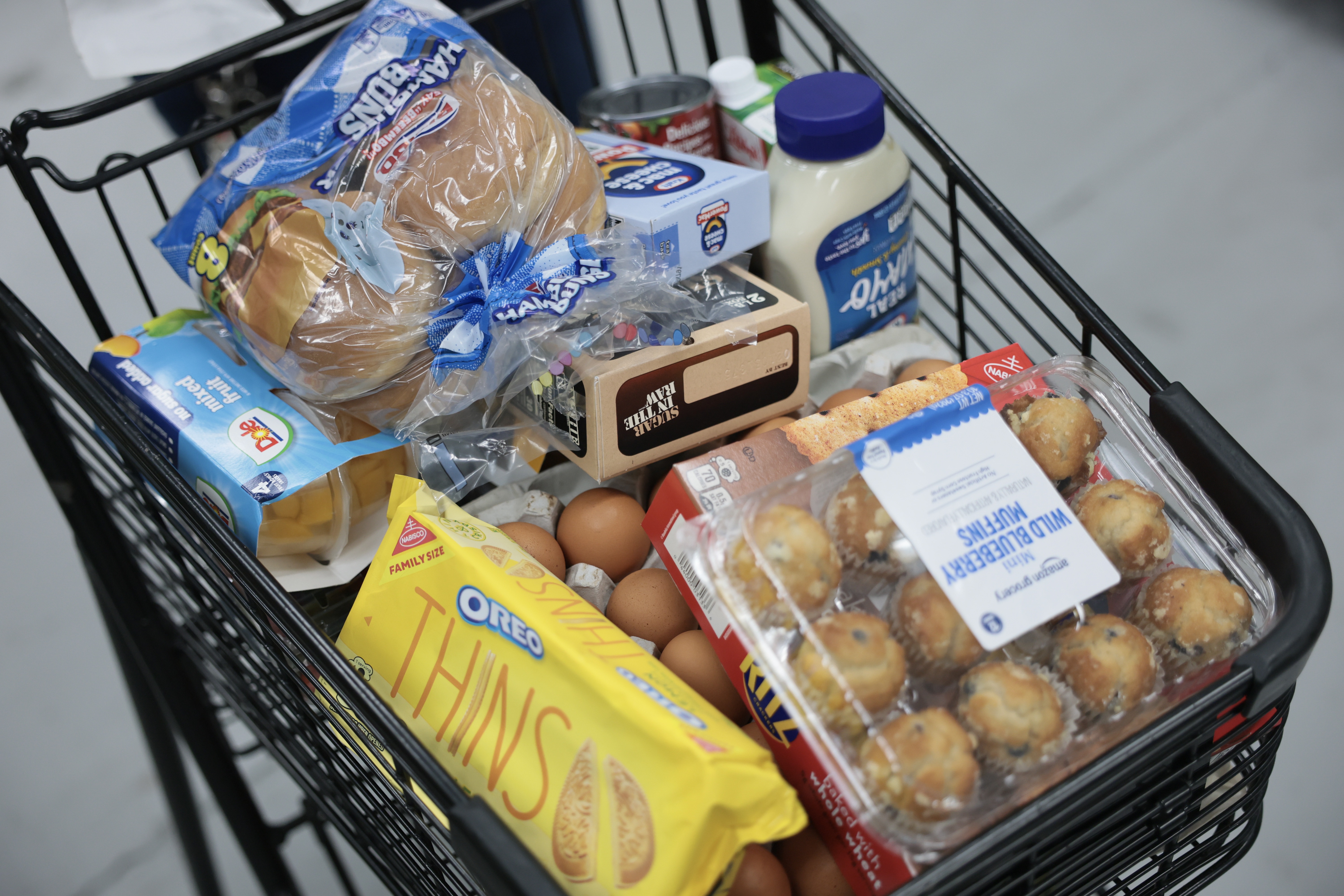 A grocery cart is full of food items as a person shops at the Feeding South Florida food pantry on July 8 in Pembroke Park, Fla.