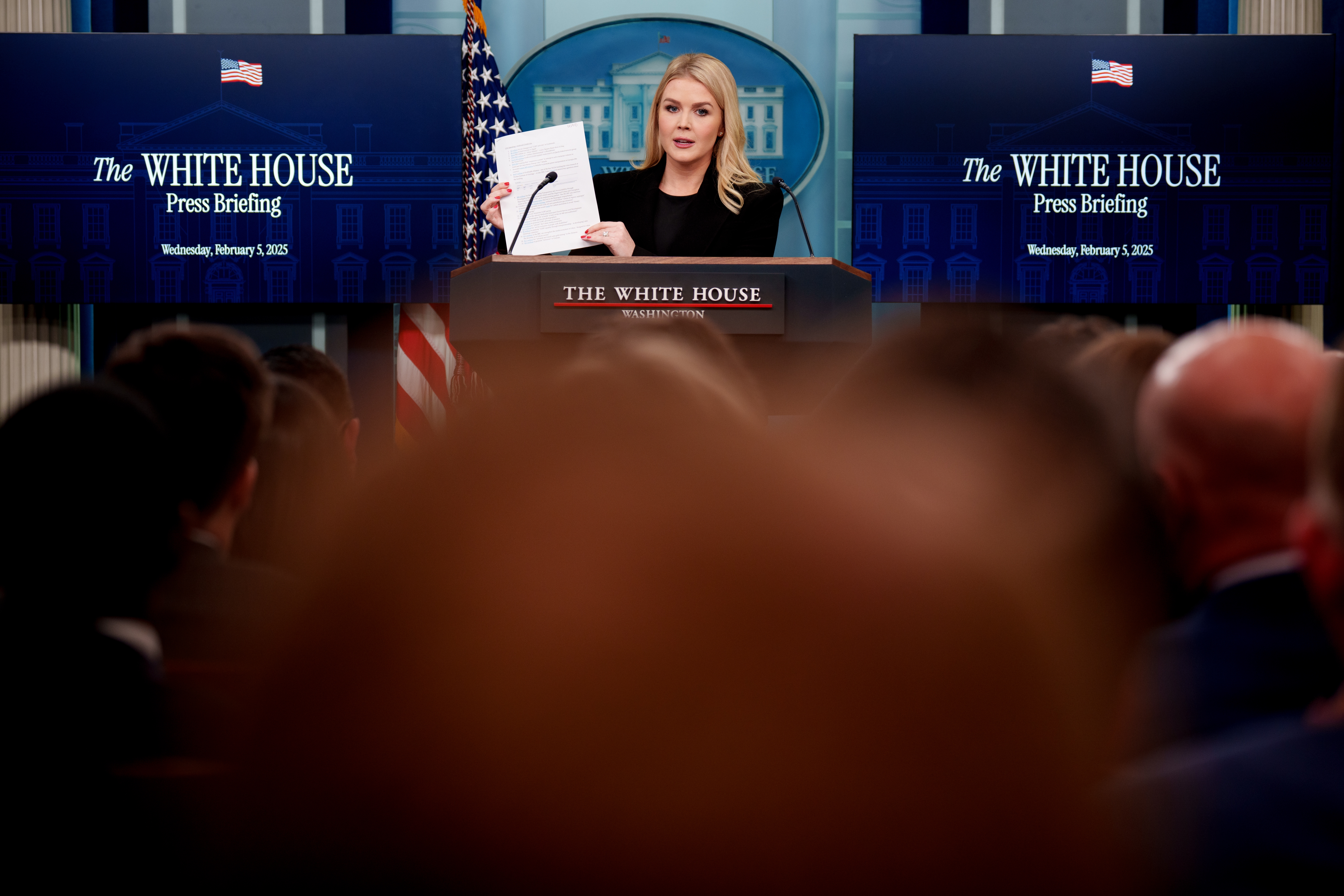 White House Press Secretary Karoline Leavitt holds up a document as she reads off line items of government spending during a news conference Wednesday in the Brady Press Briefing Room at the White House in Washington, D.C.