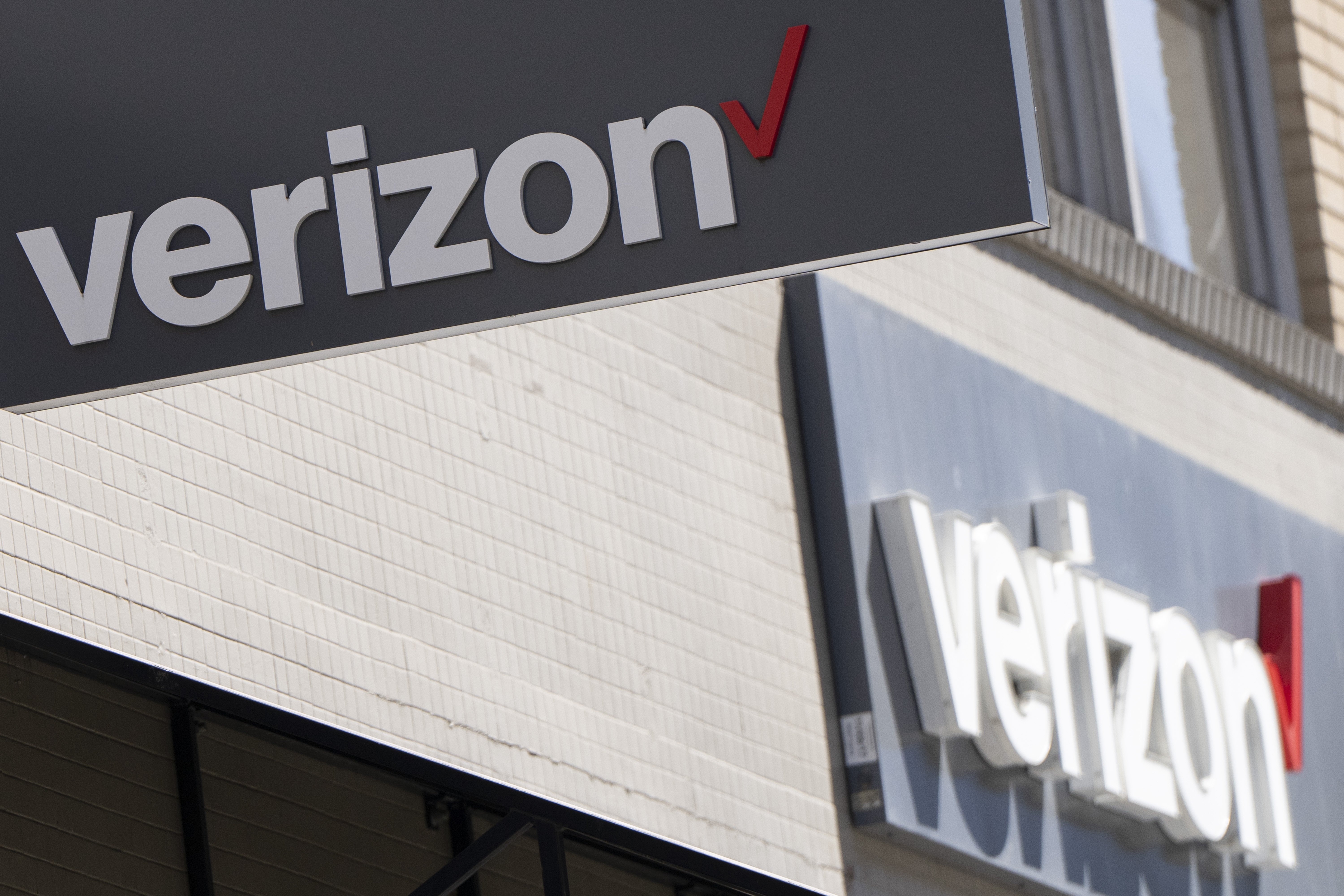 Signs are displayed outside a Verizon retail location on May 14, 2024, in Portland, Ore.