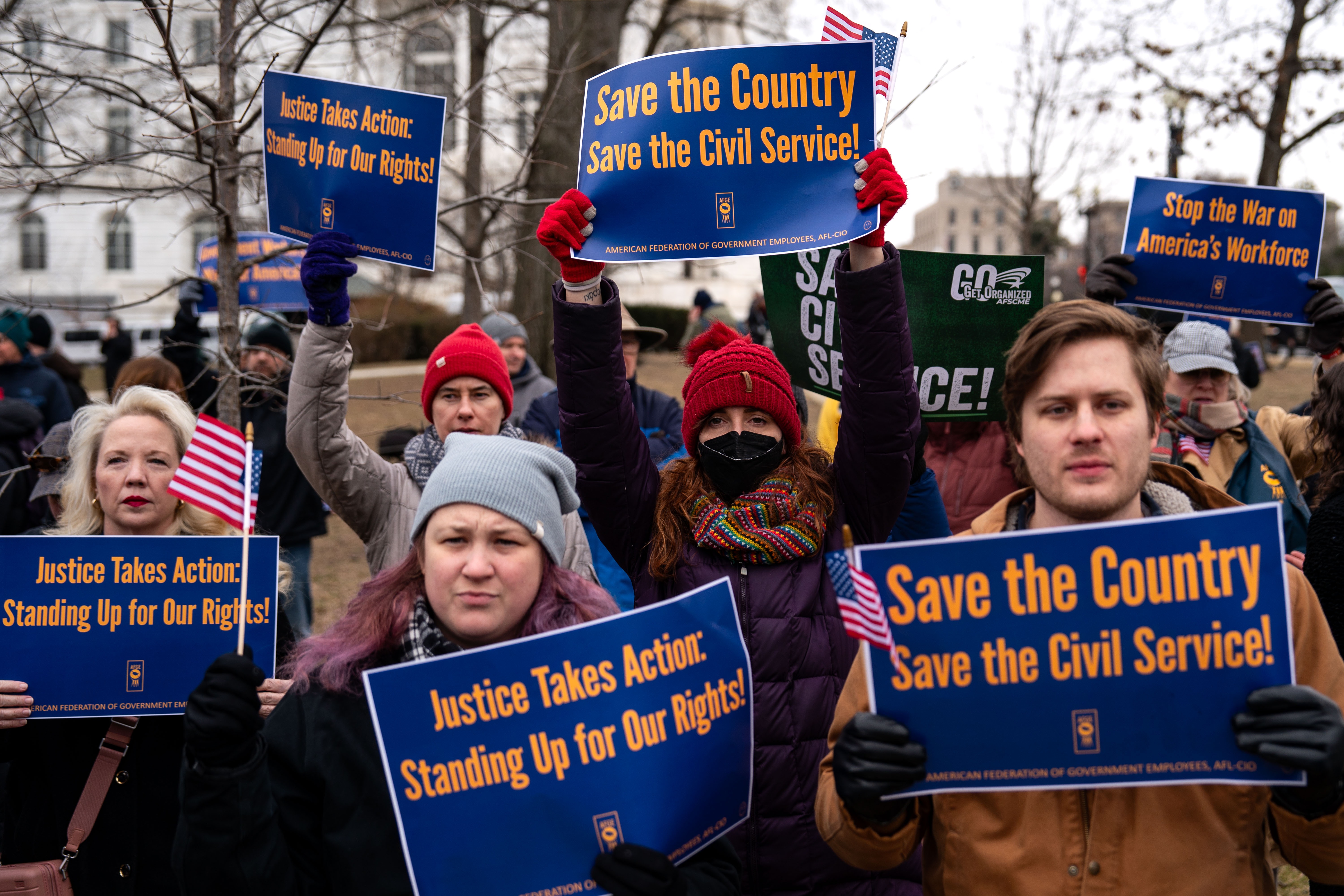 People hold signs during a "Save the Civil Service" rally outside the U.S. Capitol on Feb. 11, 2025 in Washington, D.C.