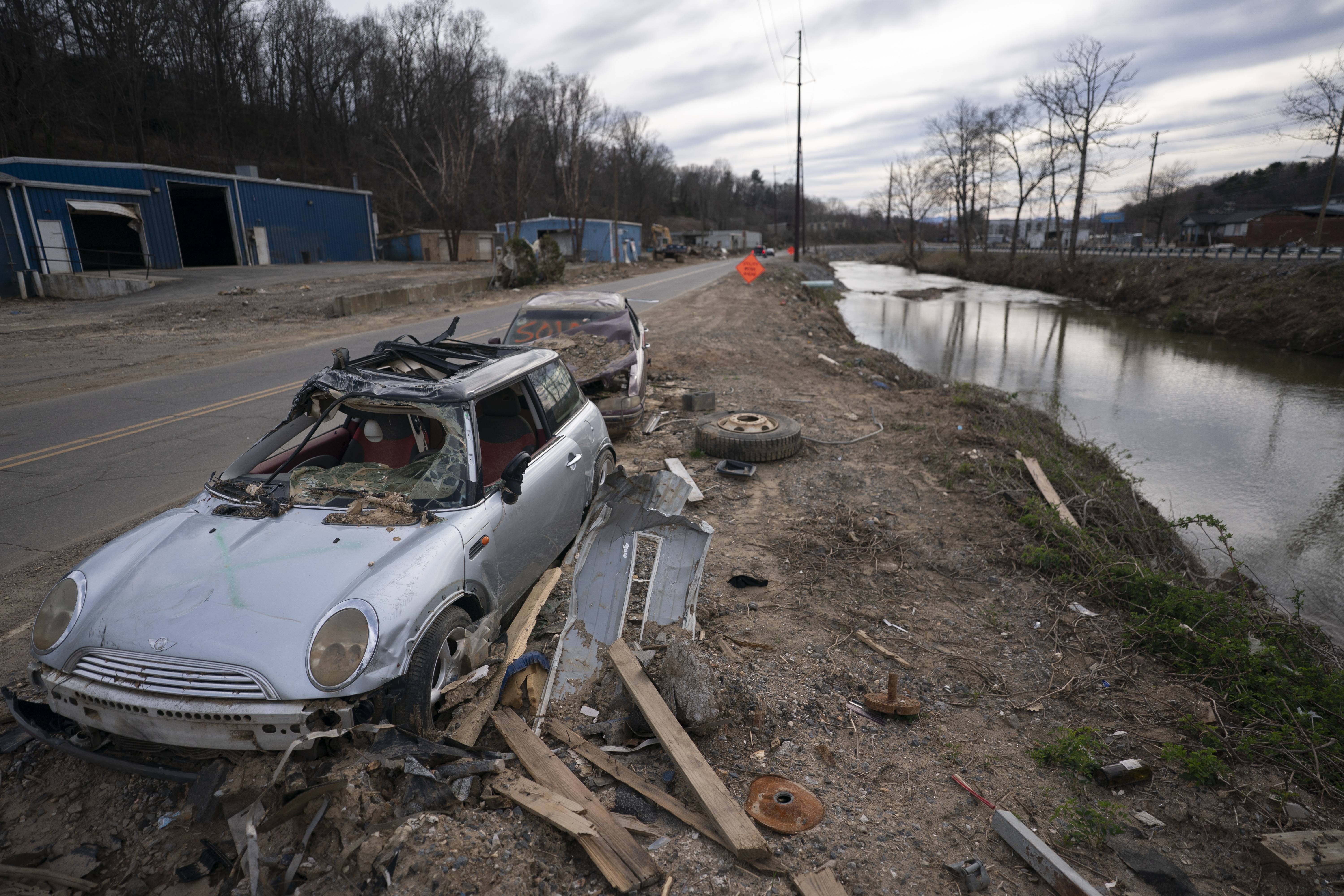 An abandoned vehicle sits along the Swannanoa River in a landscape scarred by Hurricane Helene, on March 24, near Swannanoa, N.C.