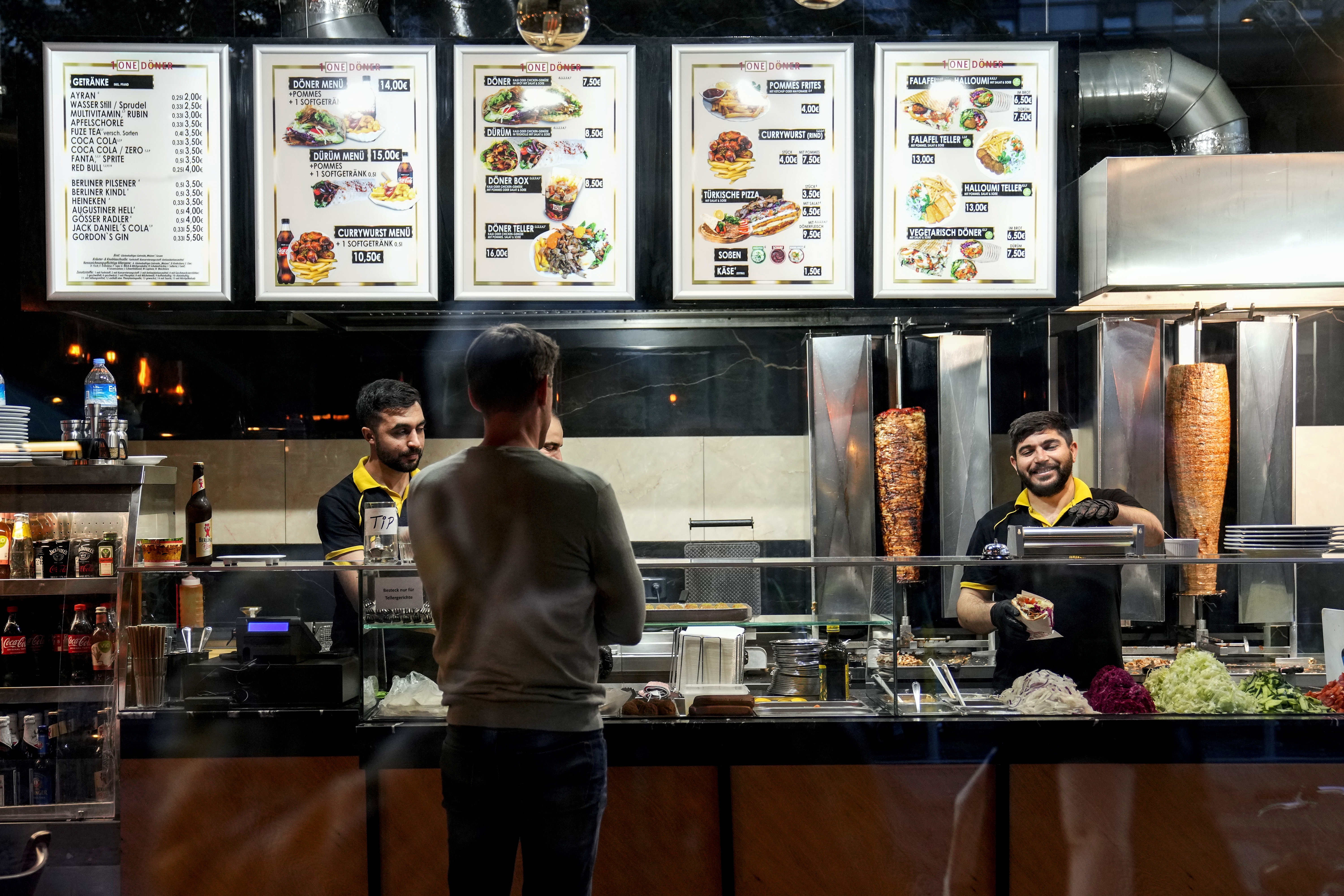 Turkish doner cooks prepare doner kebabs for customers in a doner kebab restaurant in Berlin, Germany, on Wednesday.
