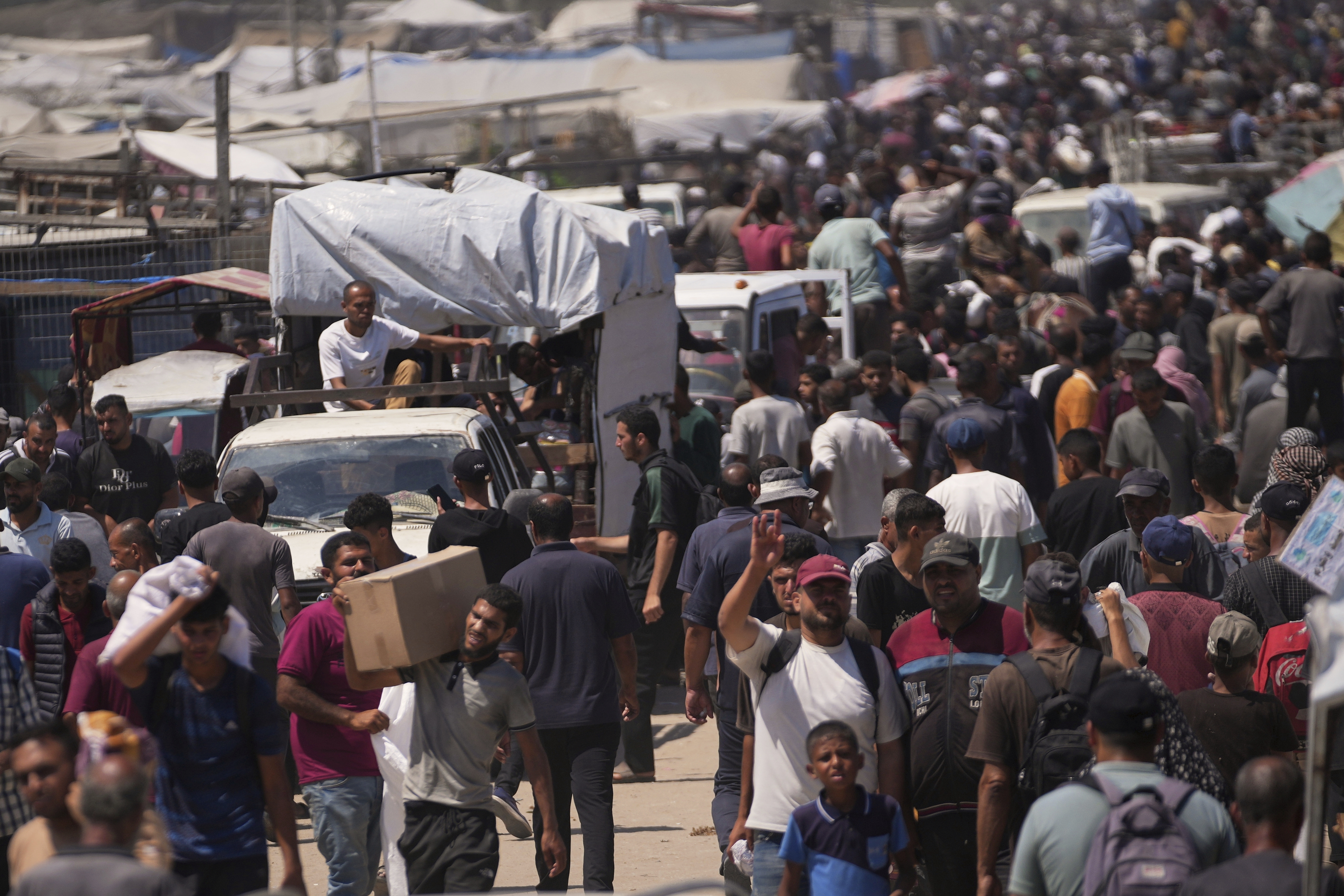 Palestinians carry bags containing food and humanitarian aid packages delivered by the Gaza Humanitarian Foundation, a U.S.-backed organization, in Rafah, southern Gaza Strip, Sunday, June 15, 2025.