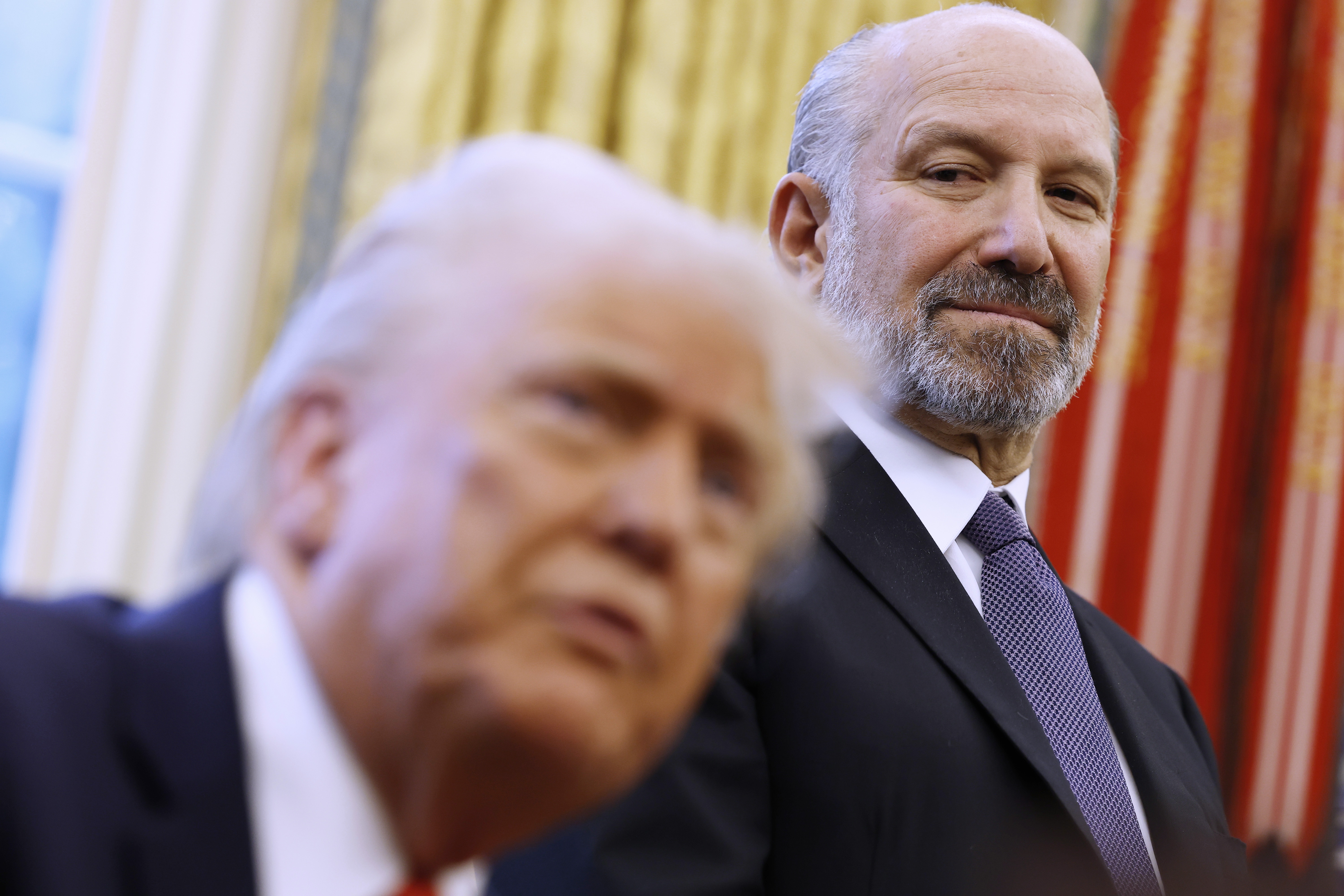 Howard Lutnick, who now oversees the Census Bureau as the commerce secretary, stands behind President Trump in the Oval Office of the White House in Washington, D.C., in February before his confirmation to Trump