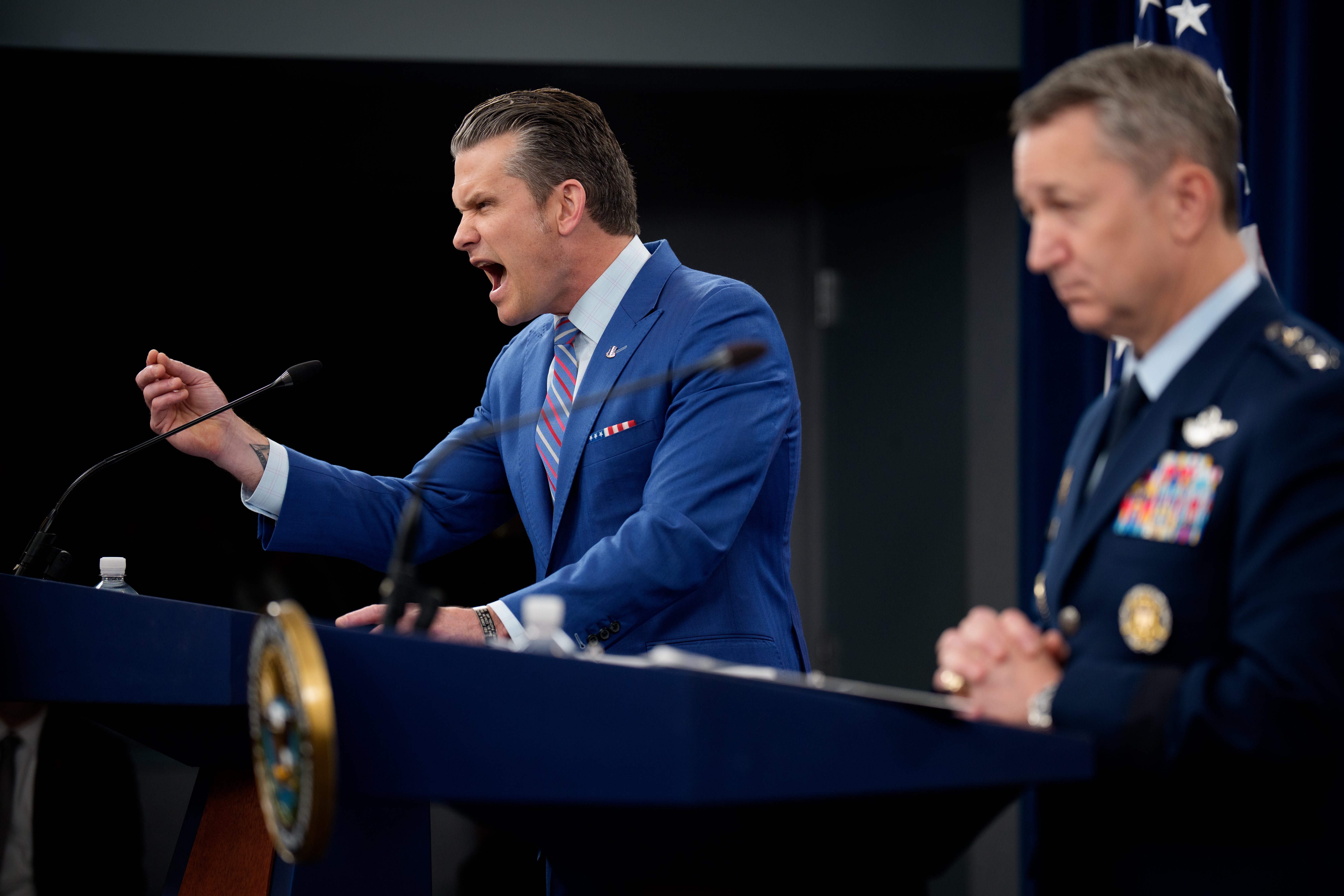 Defense Secretary Pete Hegseth (L), accompanied by Chairman of the Joint Chiefs of Staff Air Force Gen. Dan Caine (R), speaks during a news conference at the Pentagon on Thursday about the U.S. airstrikes against Iran