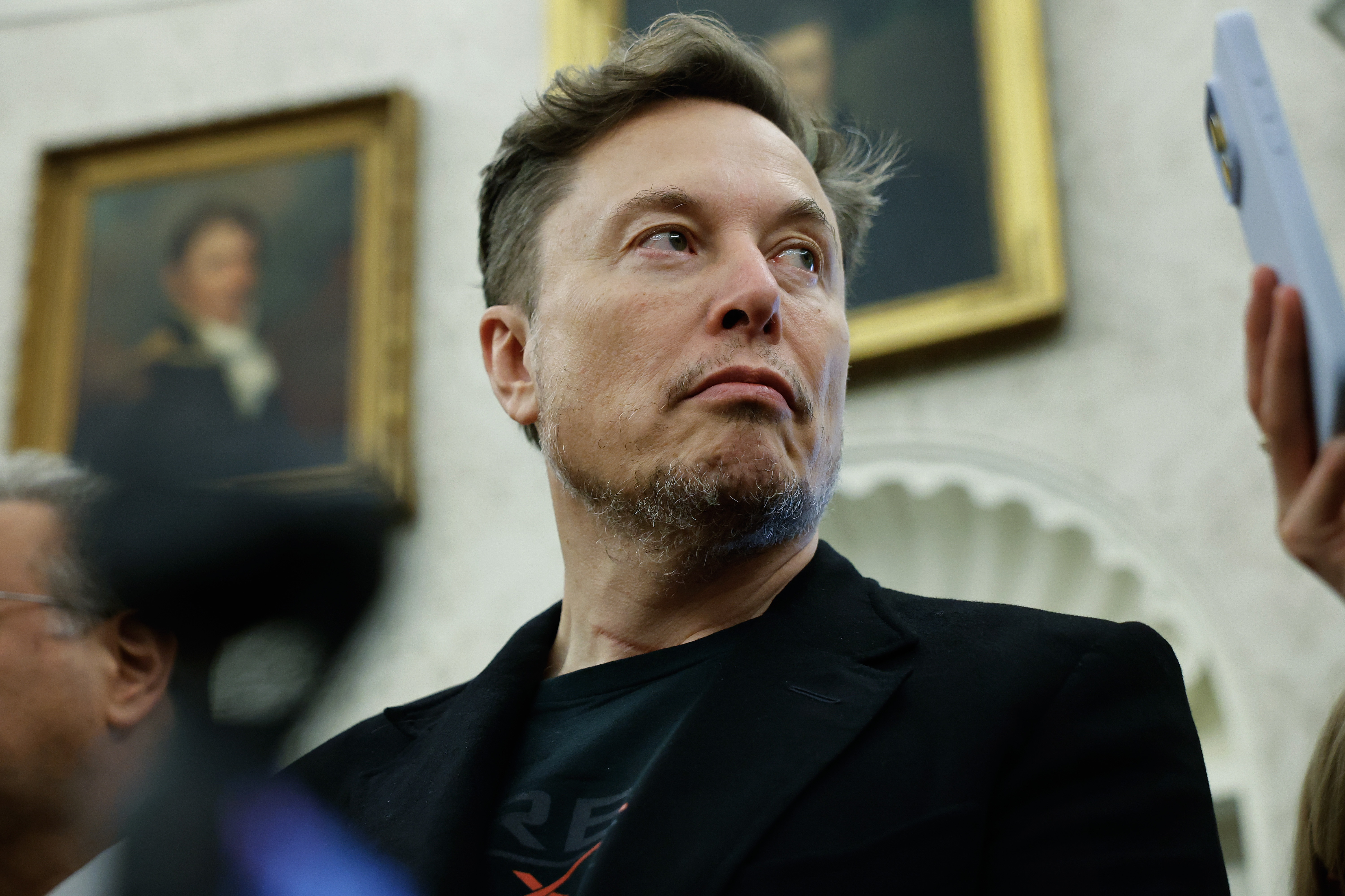Elon Musk listens during a bilateral meeting between President Trump and South Africa President Cyril Ramaphosa at the White House on May 21, 2025. Musk announced this week that he was leaving the Trump administration and returning to focus on his businesses.