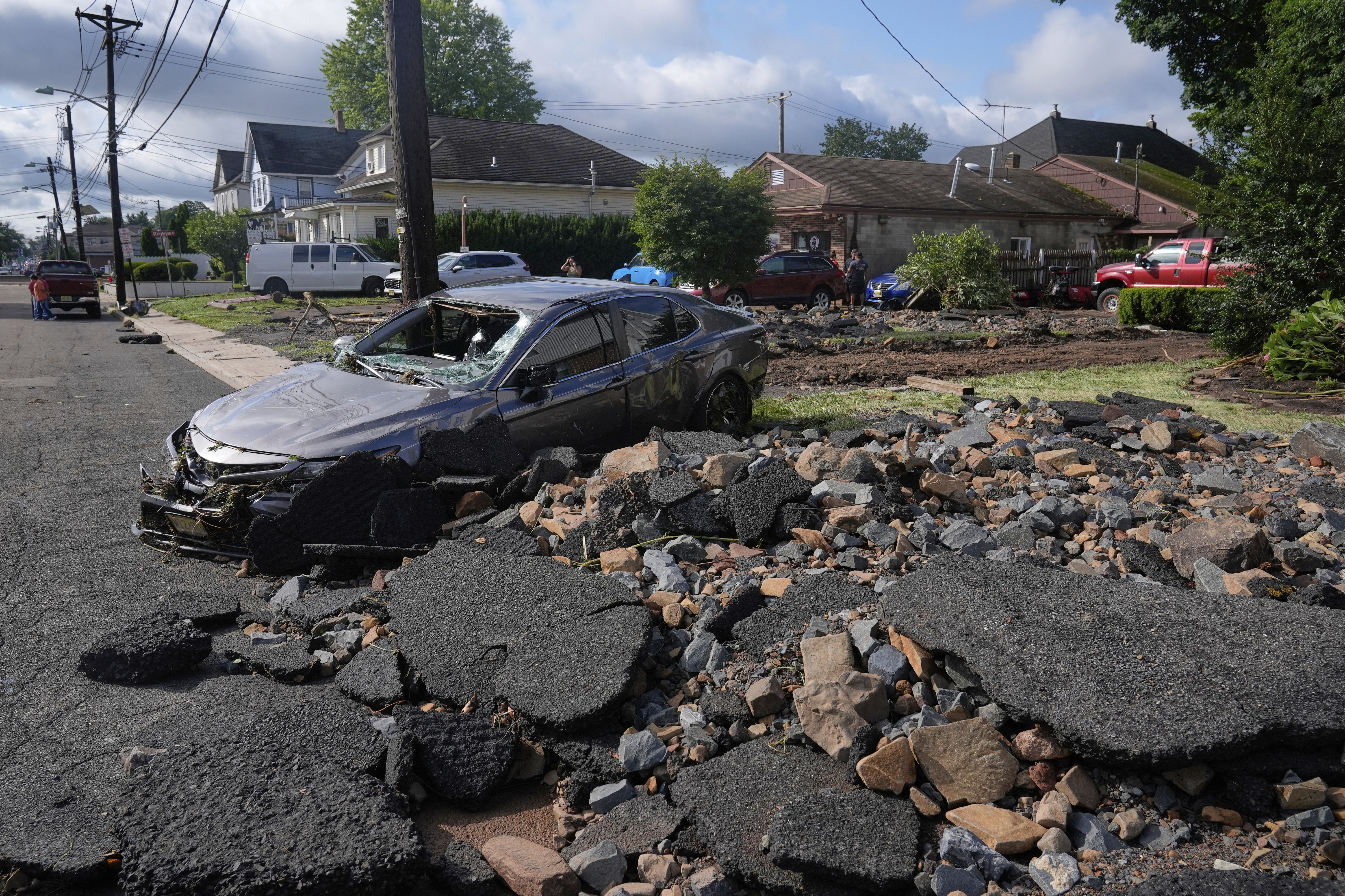 Debris, rubble and a damaged car in North Plainfield, N.J. on Tuesday, July 15, 2025 after flooding from heavy rains in the area. Climate change is causing heavier rain across the United States.