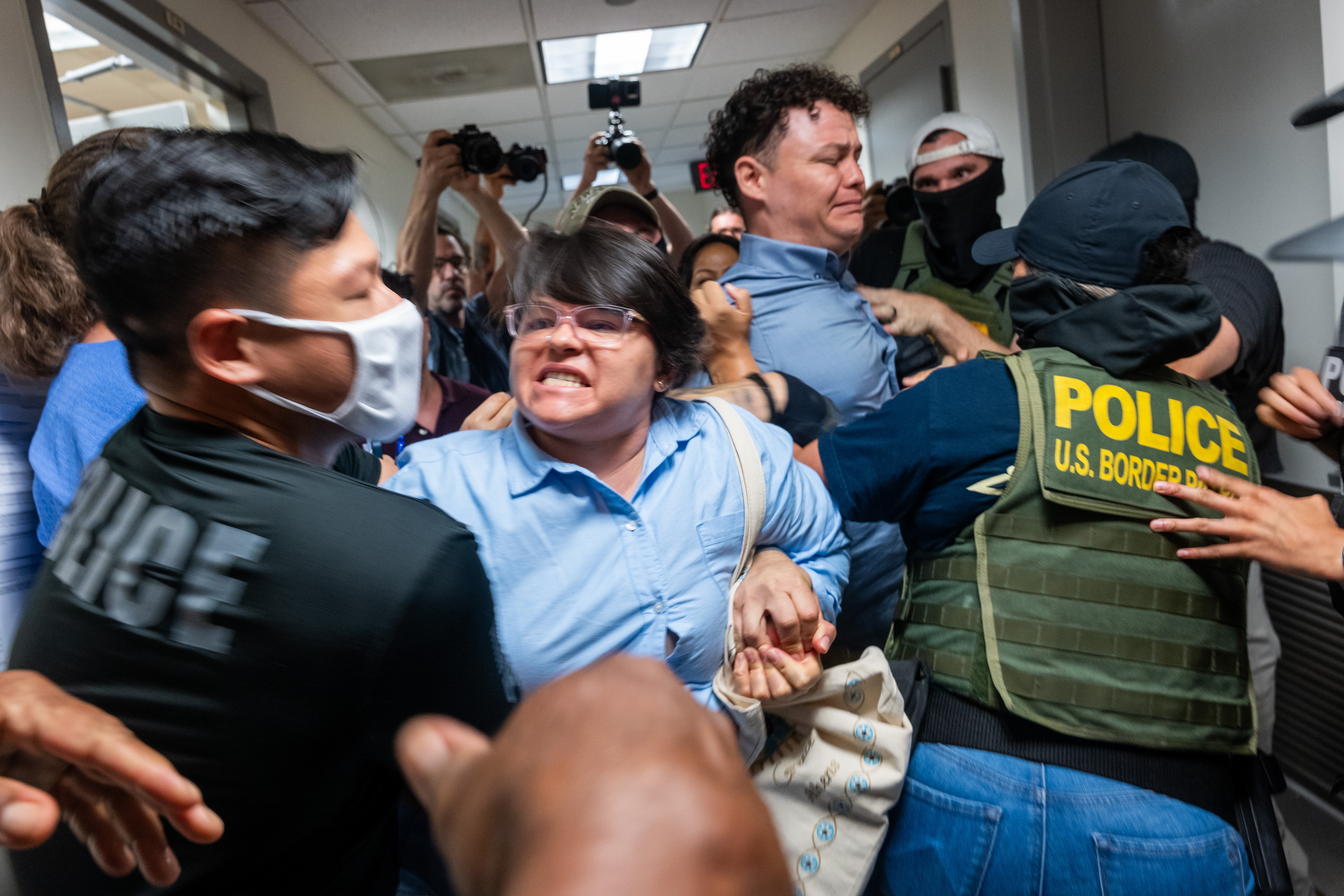 A Paraguayan woman whose relative was detained by federal agents scuffles with officers in the halls of immigration court at the Jacob K. Javitz Federal Building on in New York City in July 2025.