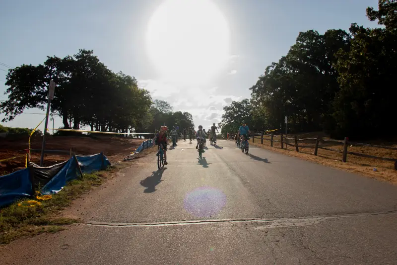Will Rogers Elementary students cruise down a hill on their route to school after a routine brake check. Parents, students and a car monitor ride about a mile from the park to the school as part of what’s called a bike bus.