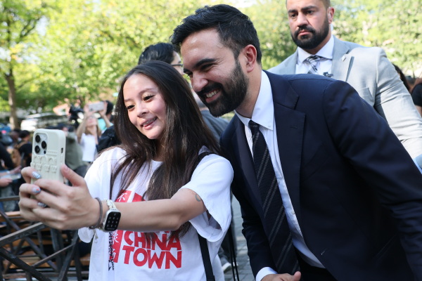 Zohran Mamdani takes a selfie with a young woman after speaking at a press conference on September 26, 2025 in New York City. Mamdani was joined by Comptroller Brad Lander, Assemblymember Tony Simone, and Assemblymember Jessica González-Rojas to condemn the ongoing raids, detentions, and actions by Immigration and Customs Enforcement (ICE) under the Trump administration. (Photo by Michael M. Santiago/Getty Images)