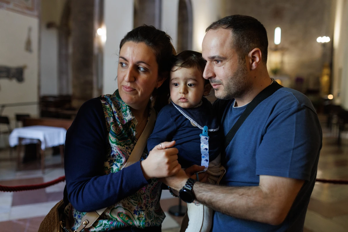 João Claro Pinto and his family in the Church of the Spoliation, where pilgrims come to visit the remains of Carlo Acutis.
