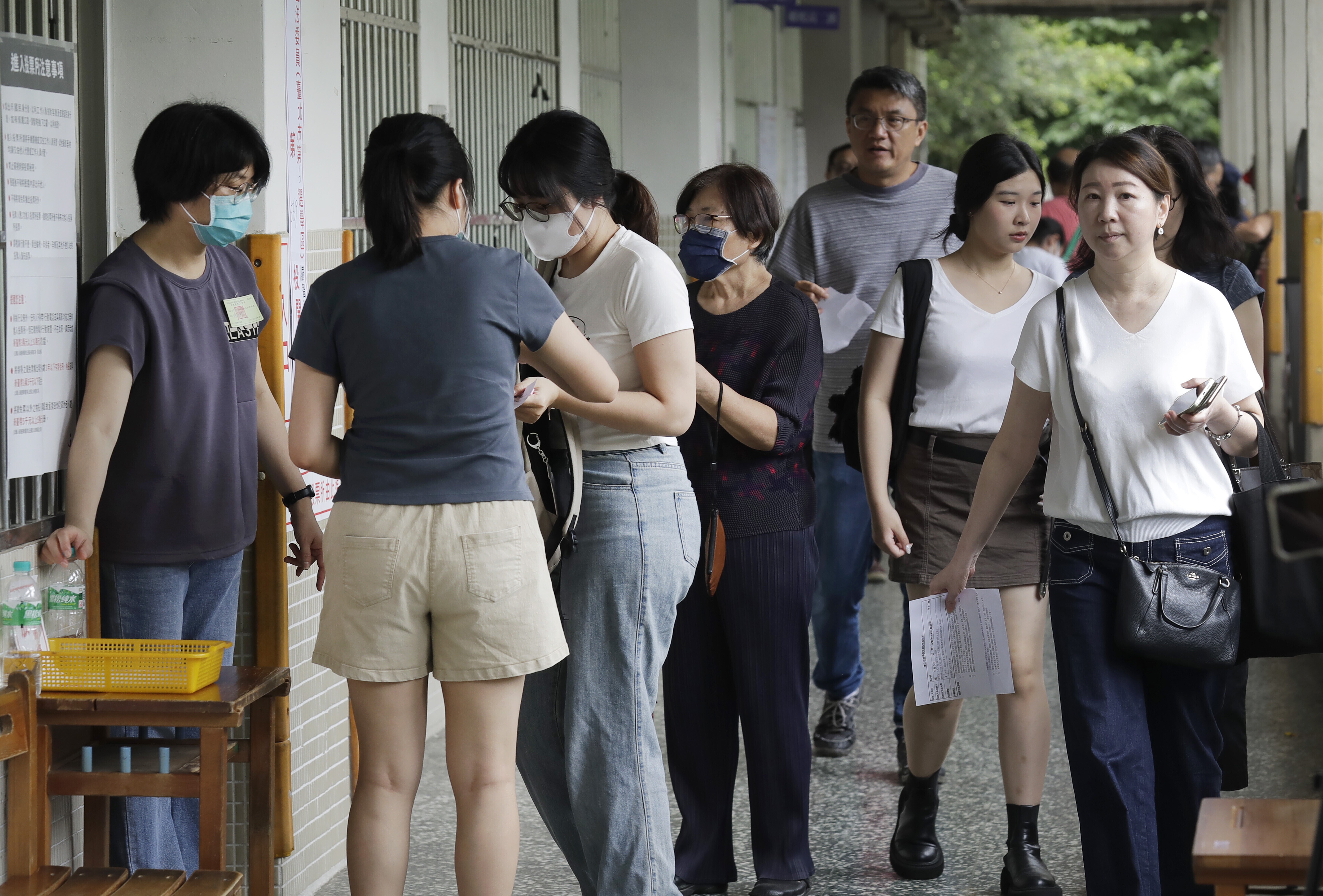 People prepare to vote at a polling station in Taipei, Taiwan, Saturday, July 26, 2025 as Taiwanese are casting their votes to determine whether to oust about one-fifth of their lawmakers, all from the opposition Nationalist Party, in elections.
